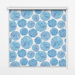 以下が含まれることがあります： 白地に青と白の抽象的な円模様が描かれたローラーブラインド。円は小さな青い点で構成されています。