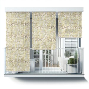 May include: White balcony with three gold geometric patterned window shades. The shades are partially rolled up, revealing a view of a balcony with a white couch, potted plants, and a table and chairs.