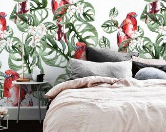 Puede incluir: Un dormitorio con una cama con un edredón de lino rosa y una cabecera blanca. La pared detrás de la cama está cubierta con un papel tapiz tropical con pájaros rojos, flores blancas y hojas verdes. El papel tapiz tiene un fondo blanco.