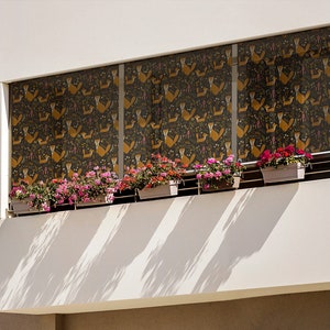 Può includere: Un edificio bianco con un balcone con una copertura per finestre a motivi e diversi vasi di fiori rosa.