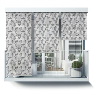 May include: White balcony with three zebra-patterned roller shades. The shades are down, displaying a repeating pattern of black and white zebras on a light gray background. The balcony has a white railing and a view of a patio set.