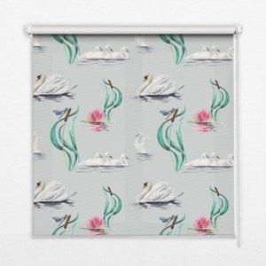 Może przedstawiać: Biała roleta z powtarzającym się wzorem łabędzi, ważek, różowych lilii wodnych i zielonych trzcin na jasnoszarym tle.