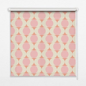 以下が含まれることがあります： ベージュの背景にピンクの円が繰り返し描かれた白いローラーブラインド