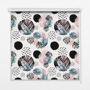 以下が含まれることがあります： 白地に黒の円、白のドット、緑、ピンク、白の熱帯の葉が繰り返される模様の白いロールブラインドです。