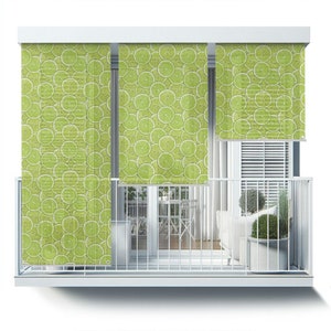 May include: Three white window blinds with a lime slice pattern. The blinds are partially rolled up, revealing a balcony with a white railing, a white couch, and potted plants.