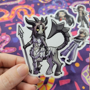 Könnte beinhalten: Ein Aufkleber mit einer Cartoon-Illustration einer grauen und schwarzen Kreatur mit Hörnern, einem Speer und einem Schwanz. Die Kreatur trägt ein weißes und graues Outfit mit einer schwarzen Schärpe. Der Aufkleber befindet sich auf einem lila und gelben Hintergrund.
