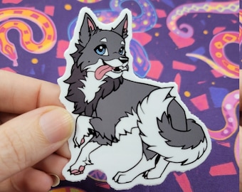 Pode incluir: Um autocolante com um lobo de desenho animado com pelo cinzento e branco, olhos azuis e a língua de fora. O lobo está numa pose brincalhona, com uma pata levantada. O fundo é um tecido roxo com um padrão de cobra.