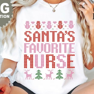 May include: White t-shirt with a festive design. The shirt features the text "SANTA'S FAVORITE NURSE" in red and pink, along with snowman, deer, and Christmas tree graphics. The words "PNG SUBMLIMATION" are also visible.