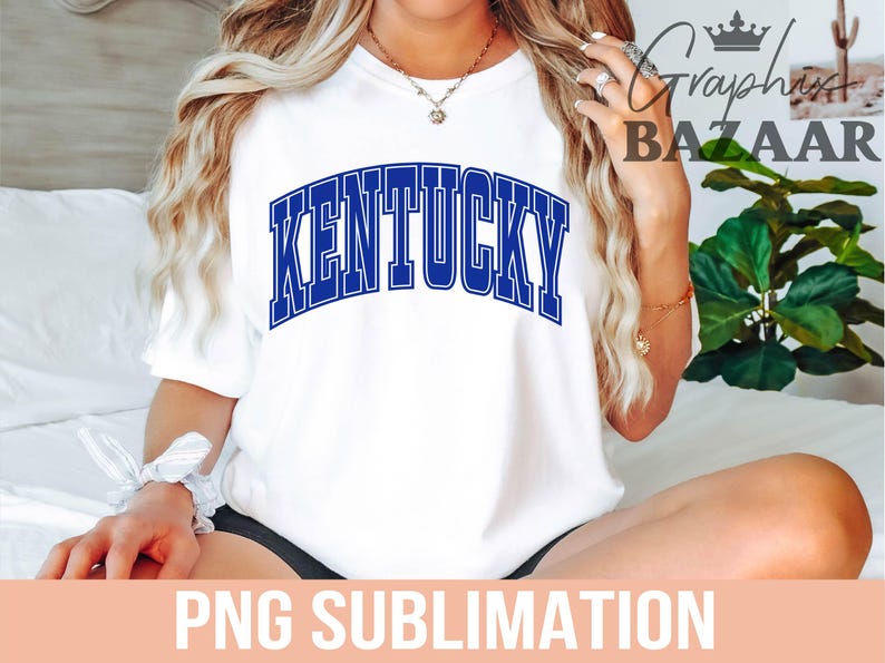 May include: White t-shirt with the word "KENTUCKY" in blue, arched lettering. The shirt is a casual style, suitable for everyday wear. The image also includes the text "PNG SUBLIMATION".