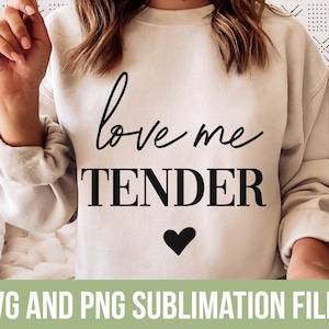 May include: A white sweatshirt with the text "love me tender" in black lettering and a small black heart below the text.