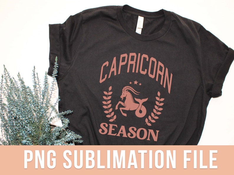 K&ouml;nnte beinhalten: Schwarzes T-Shirt mit einer braunen Grafik eines Steinbock-Sternzeichen und dem Text "Steinbock-Saison".