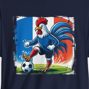 Op de afbeelding: Een marineblauw t-shirt met een afbeelding van een haan die voetbal speelt voor een Franse vlag. De haan draagt ​​een rode broek en blauwe sokken.