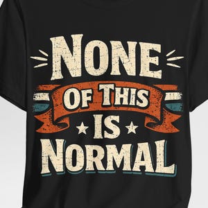 May include: Black t-shirt featuring the phrase "NONE OF THIS IS NORMAL" in a vintage, distressed font. The text is white, with an orange banner and blue details. The shirt has a crew neck design.