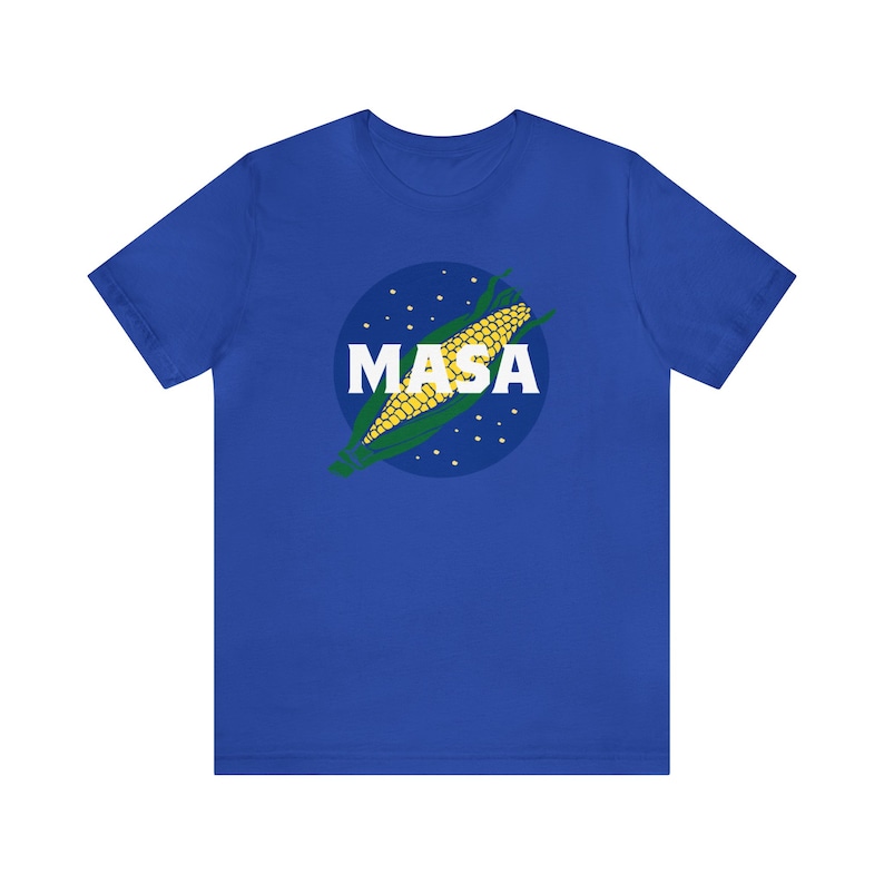 May include: A royal blue t-shirt with a white circle graphic featuring a corn cob and the word "MASA" in white letters.