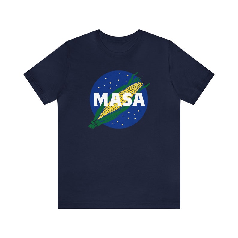 May include: A navy blue t-shirt with a graphic of a corn cob in a blue circle with white stars and the word "MASA" in white letters.