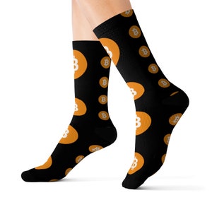 May include: Black socks with a repeating pattern of orange circles containing a white Bitcoin symbol.