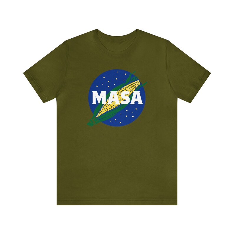 May include: A green t-shirt with a blue and white circle graphic featuring a corn cob and the word "MASA" in white letters.