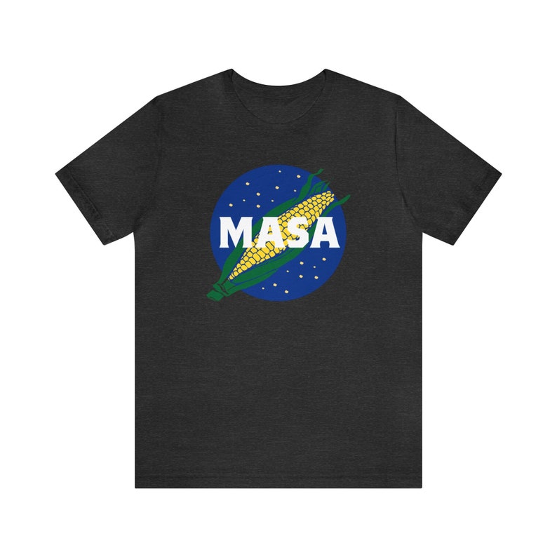 May include: A dark heather grey t-shirt with a blue and white graphic of a corn cob with the word "MASA" printed in white.