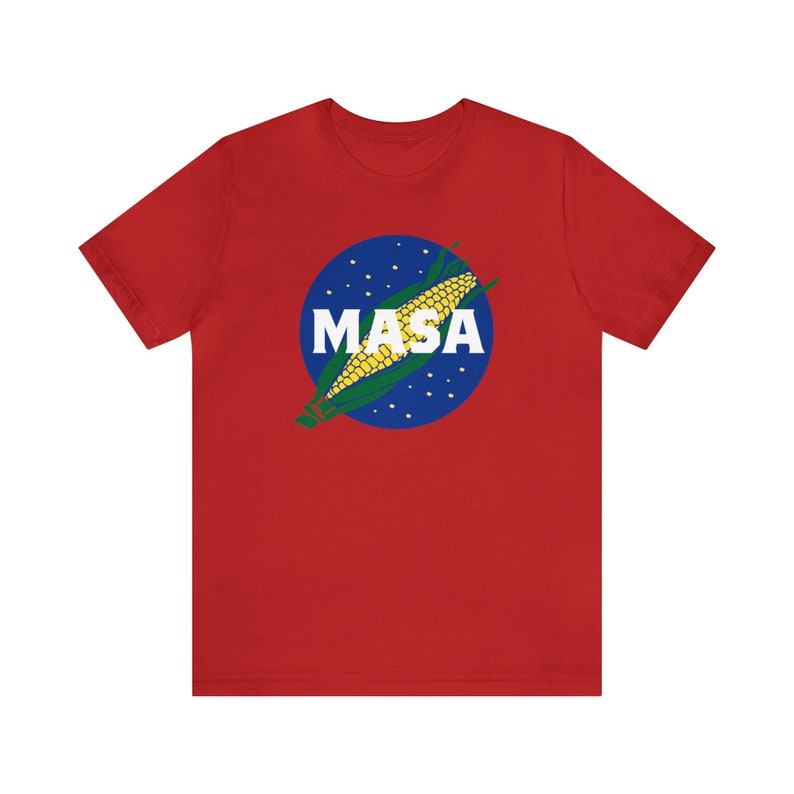 May include: Red t-shirt with a blue and white circle graphic featuring a corn cob and the word "MASA" in white letters.