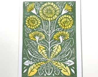 May include: A green and yellow linocut print of a stylized dandelion flower arrangement. The print is titled "Autumn Hawbit" and numbered 2/10.