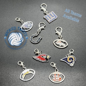 May include: A collection of silver-toned charms featuring various team logos, including a horseshoe, a cardinal, and a football. The charms have lobster claw clasps. Text on the image reads "All Teams Available" and "Wicked Twists".
