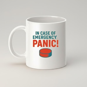 May include: White ceramic mug with the text "IN CASE OF EMERGENCY, PANIC!" in teal and red. A red and teal graphic of a button is below the text. The mug has a white handle and is set against a light background.