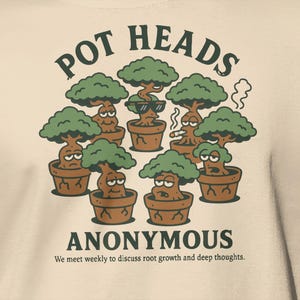 May include: Cream-colored t-shirt featuring a cartoon graphic of several potted trees with expressive faces. The text "POT HEADS ANONYMOUS" is above and below the illustration, with the tagline "We meet weekly to discuss root growth and deep thoughts."