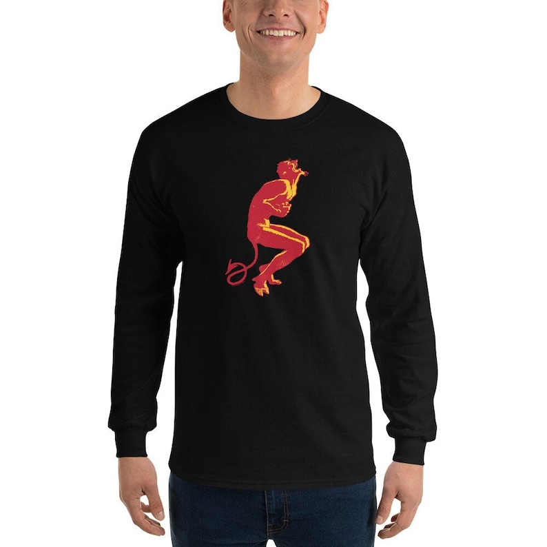 May include: A black long-sleeve t-shirt with a red and yellow silhouette of a devil figure with a tail.