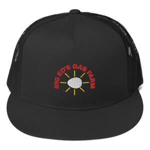 May include: Black trucker hat with a black mesh back. The front of the hat features a red embroidered logo that says "Big Ed's Gas Farm" with a white sun and yellow rays.