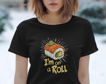 May include: Black t-shirt with a sushi roll graphic and the text "I'm on a Roll" in yellow. The sushi design includes salmon, avocado, and rice, topped with a green garnish. The design is surrounded by white radiating lines.