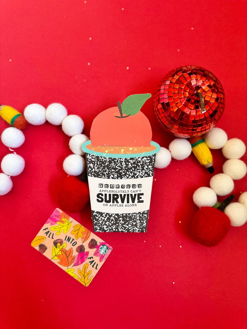 May include: A whimsical image featuring a paper cup with an apple on top, the text "APPLESOLUTELY CAN'T SURVIVE ON APPLES ALONE", and a card with fall leaves. A red disco ball and decorative elements are also present.