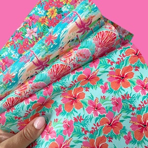 May include: A stack of colorful fabric with a tropical floral print. The fabric features hibiscus flowers, palm trees, and a blue and green background.