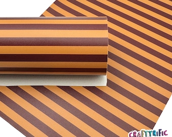 May include: A roll of brown and orange striped faux leather. The leather is textured and has a slight sheen. The roll is partially unrolled, revealing the pattern of the leather.
