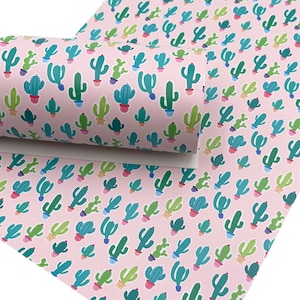 May include: Pink fabric with a repeating pattern of green, blue, and yellow cacti in pots. The cacti are in various sizes and shapes.