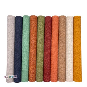 May include: Ten rolls of faux leather fabric with a lace pattern. The colors are light gray, navy blue, light green, orange, dark green, burgundy, coral, brown, white, and yellow.