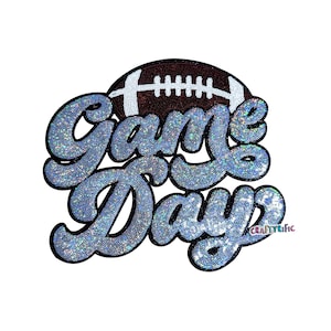May include: A decorative applique with the words "Game Day" in a sparkling, light blue font. A brown football with white stitching is above the text. The word "Craftyrific" is in the lower right corner.