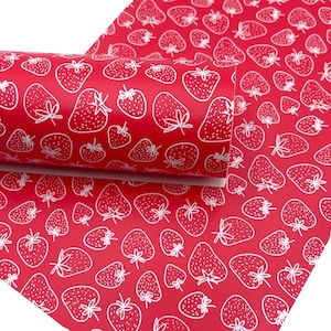 May include: Red fabric with a white strawberry pattern. The strawberries are outlined in white and have small white dots inside.
