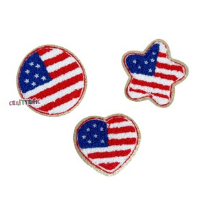 May include: Three felt American flag patches in different shapes: a circle, a star, and a heart. The patches are red, white, and blue with gold glitter trim.
