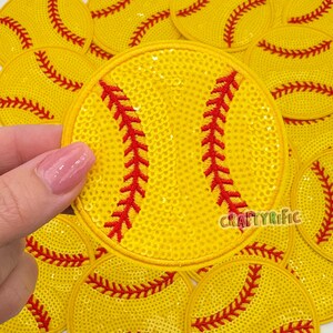May include: Yellow sequined softball patches with red stitching details. The patches are round and feature the word "CraftyRific". The patches are ideal for crafting and sports-themed projects.