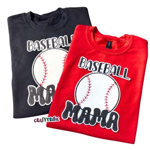 May include: Two sweatshirts with the text "Baseball Mama" and a baseball graphic. One sweatshirt is black and the other is red.