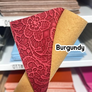 May include: Burgundy faux leather with a red lace pattern. The back side of the leather is a solid tan color.