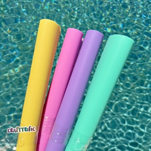 May include: Four colorful pool floats in yellow, pink, purple, and turquoise. The floats are made of a soft, flexible material and are perfect for lounging in the pool.