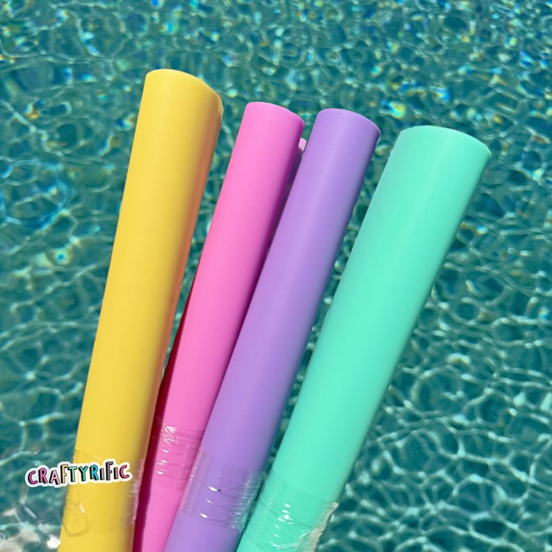May include: Four colorful pool floats in yellow, pink, purple, and turquoise. The floats are made of a soft, flexible material and are perfect for lounging in the pool.