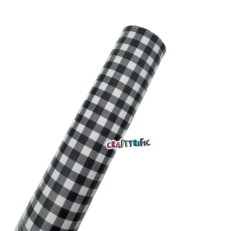 May include: A roll of black and white gingham patterned material. The material is rolled up, displaying the repeating checkered pattern. The text "CRAFTYRIFIC" is visible on the roll.