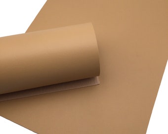 May include: A roll of light brown faux leather fabric. The fabric has a textured surface.