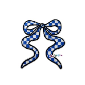 May include: A blue and white checkered bow-shaped patch with a black outline. The patch has two long, wavy tails. The text "CRAFTYrific" is visible on the lower right side of the patch.