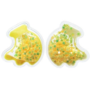 Könnte beinhalten: Zwei transparente, bananenförmige Ornamente aus Kunststoff, gefüllt mit gelben und grünen Glitzersternen.