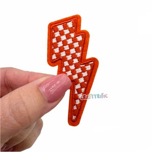 May include: Orange and white checkered lightning bolt iron-on patch.