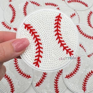 May include: White sequined baseball patch with red stitching details. The patch is round and features the classic baseball design. The word "CRAFTYrific" is visible on the patch. Several similar patches are in the background.