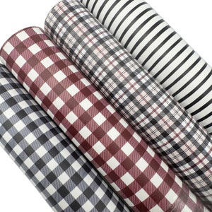 May include: Four rolls of patterned faux leather in various designs. The patterns include gray and white gingham, burgundy and white gingham, black and white plaid, and black and white stripes. The rolls are tightly wound and ready for crafting.